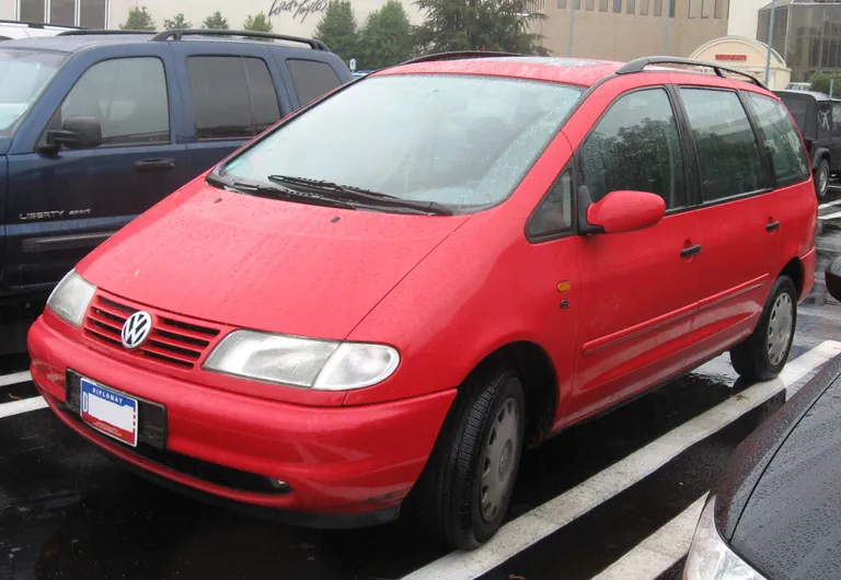 Красный Volkswagen Sharan первого поколения на городской парковке